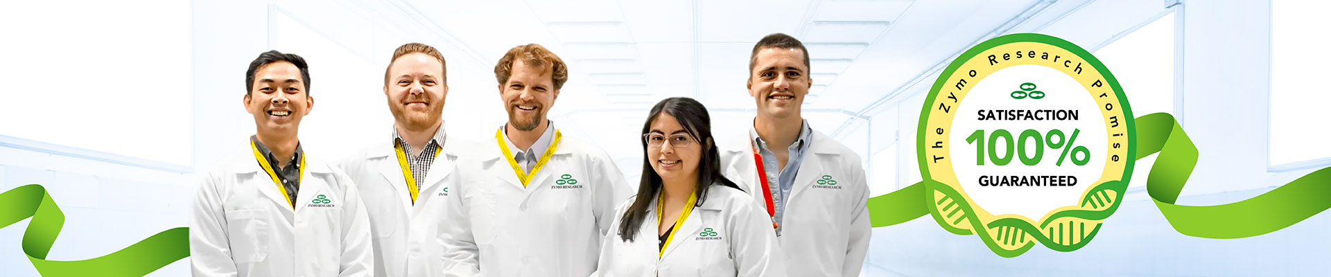 A group of five Zymo Research scientists standing in a bright, modern lab environment, all wearing white lab coats with the Zymo Research logo. They are smiling, with yellow lanyards and one with a red lanyard. On the right side, a green ribbon wraps around a circular badge that reads 'The Zymo Research Promise – Satisfaction 100% Guaranteed,' featuring DNA imagery.