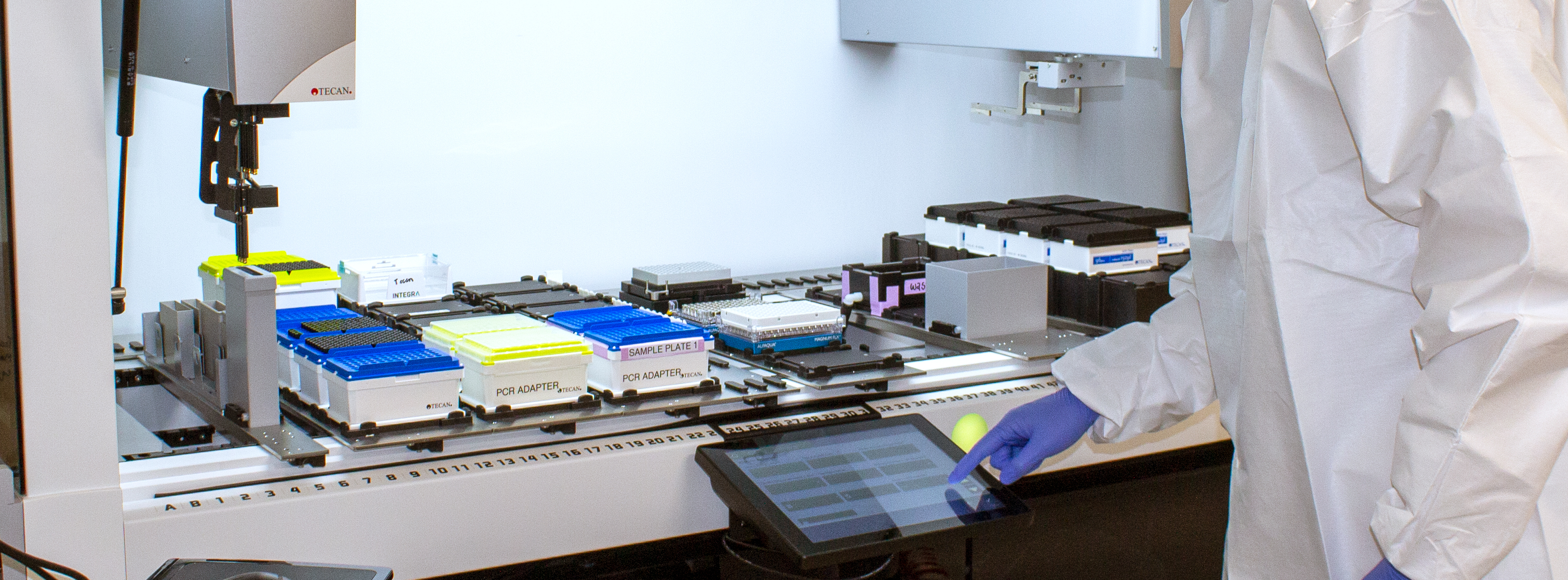 A researcher using a machine to extract RNA from saliva samples.