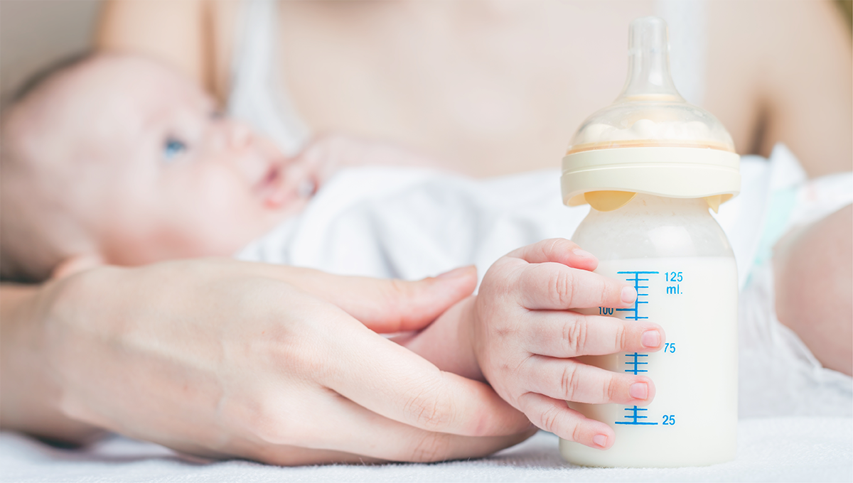 Baby holding milk bottle