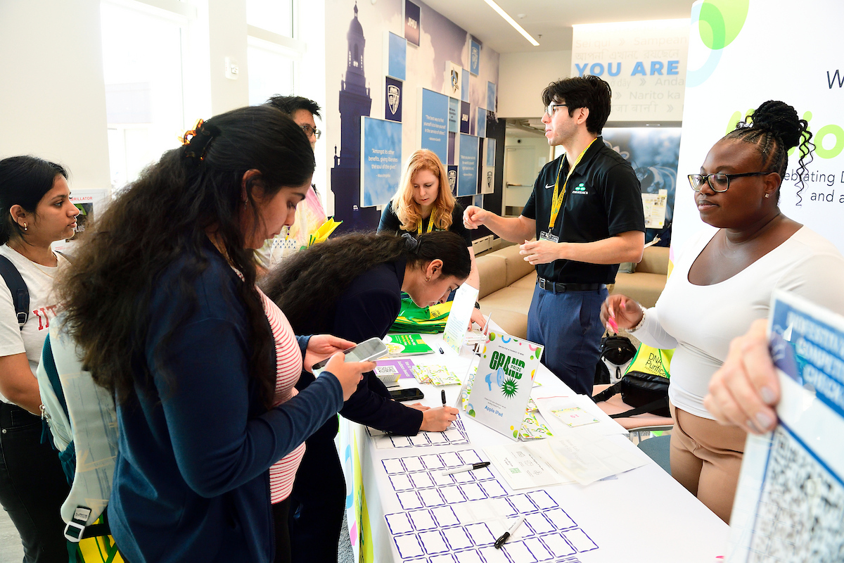 Attendees interact with Zymo Research representatives at the BioFestival booth, signing up for activities and collecting event materials.
