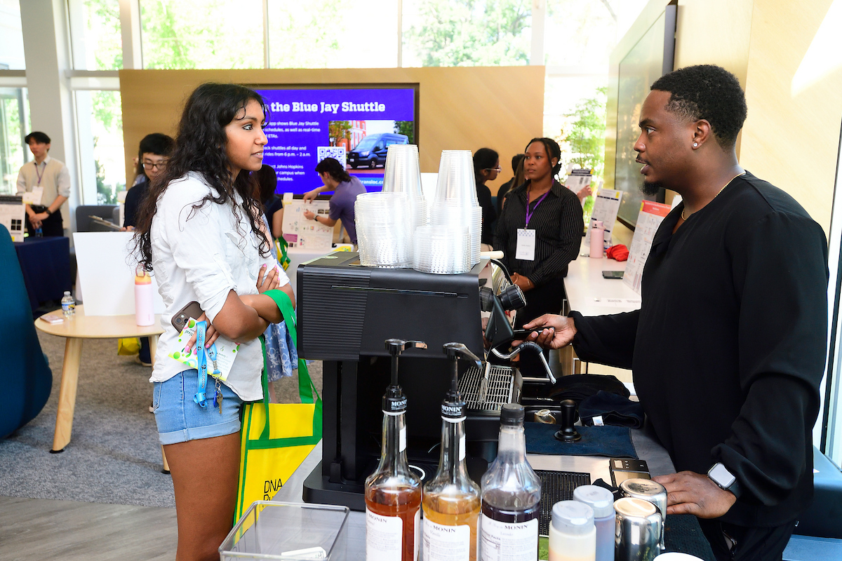 An attendee talks with a barista while ordering a drink at a coffee station during the BioFestival event.