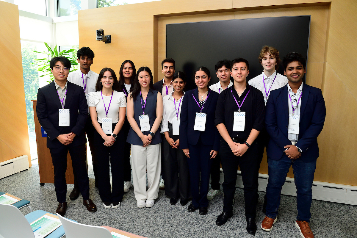 A group of BioFestival grant award winners pose together for a group photo, smiling and wearing event badges in a conference setting.