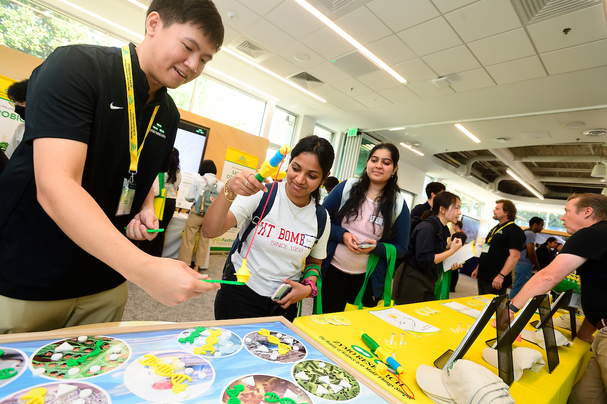 An attendee participates in a hands-on DNA extraction modeling activity at a Zymo Research booth during the BioFestival event.
