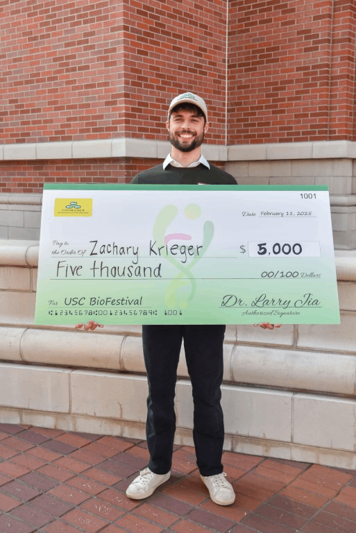 Zach Kireger holding their award of $5000