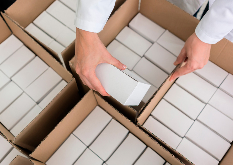Image of a person placing boxes of kits into packaging boxes
