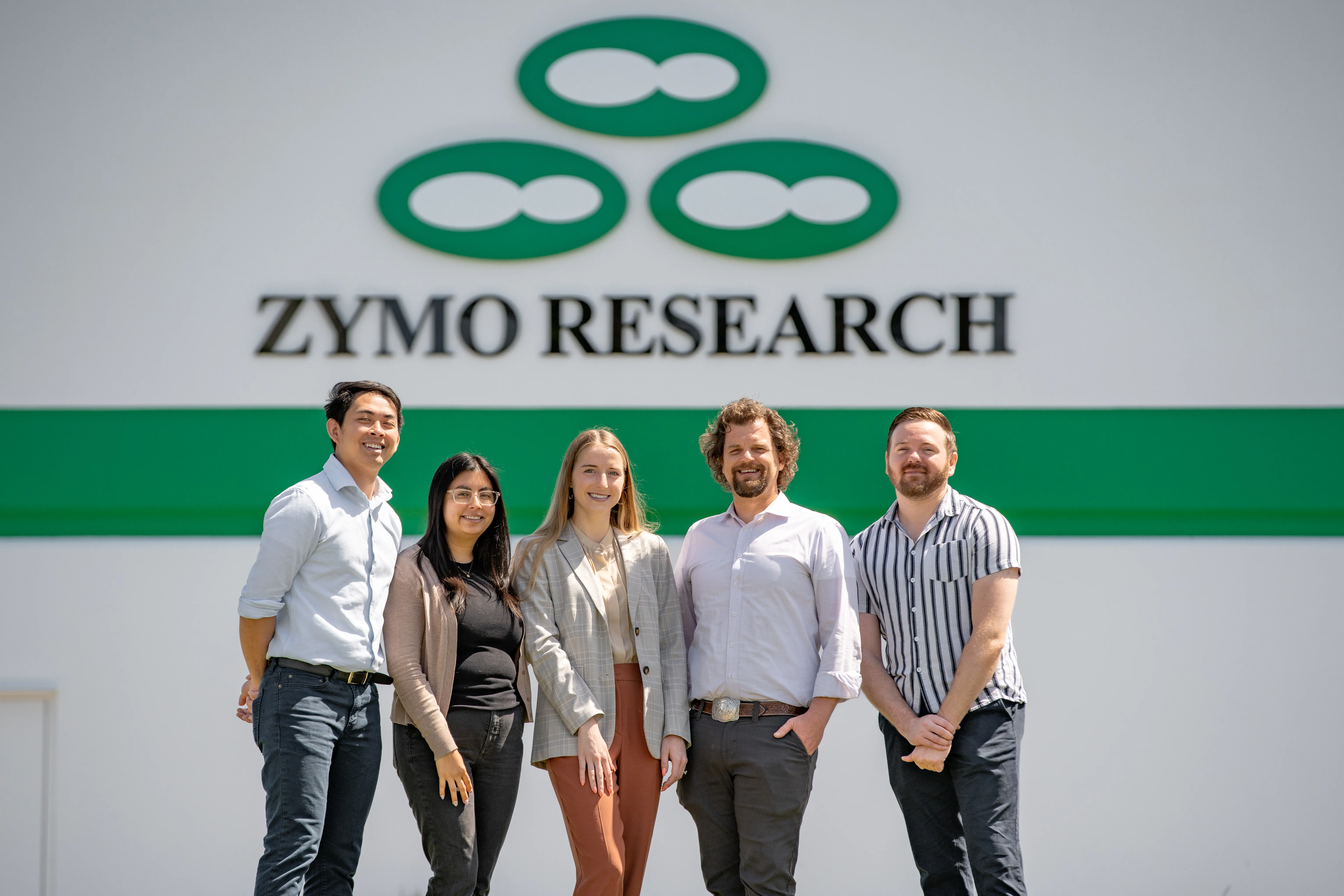 A group of microbiome scientists standing in front of Zymo Research headquarters